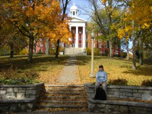 Jess sitting along the bench by the Wittenberg seal with Myers Hall in the background. When Jess lived here, it wasn't so nicely painted.