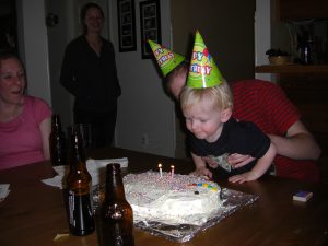 John tries valiently to blow out the candles on his fish cake.