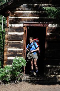 Erin looks right at hhome coming out the door of the smaller cabin. It even has some lovely landscaping.