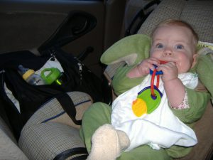 Dragon baby chews her keys on the way home.