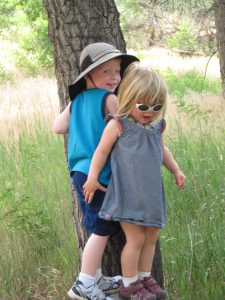 The kids are (whiningly) trying to stand on the same stump.