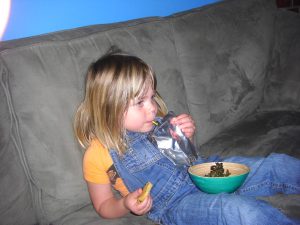 A juice box, a cookie in one hand, and a bowl of kale chips. What could be finer?