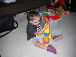 Building a block tower while wearing Phoebe's tennis shoes.