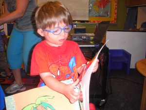 Showing me his preschool scrapbook.